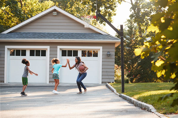 Girls playing basketball outside in the driveway