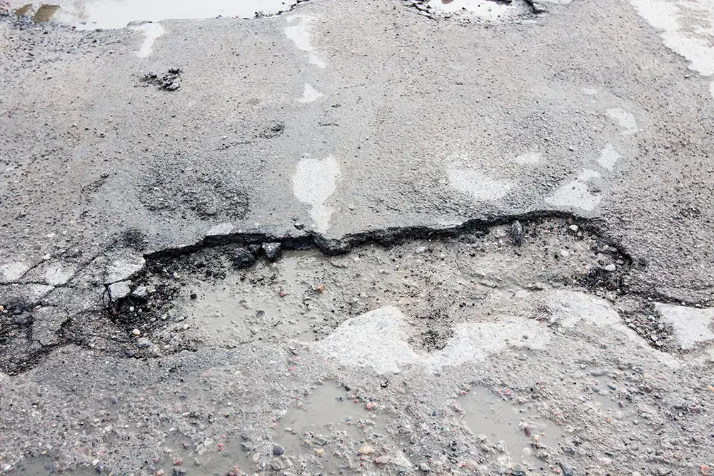 a shallow hole in concrete from delamination